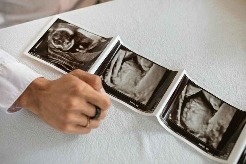 Current image: A hand holding a series of ultrasound images, symbolizing new beginnings and family planning.